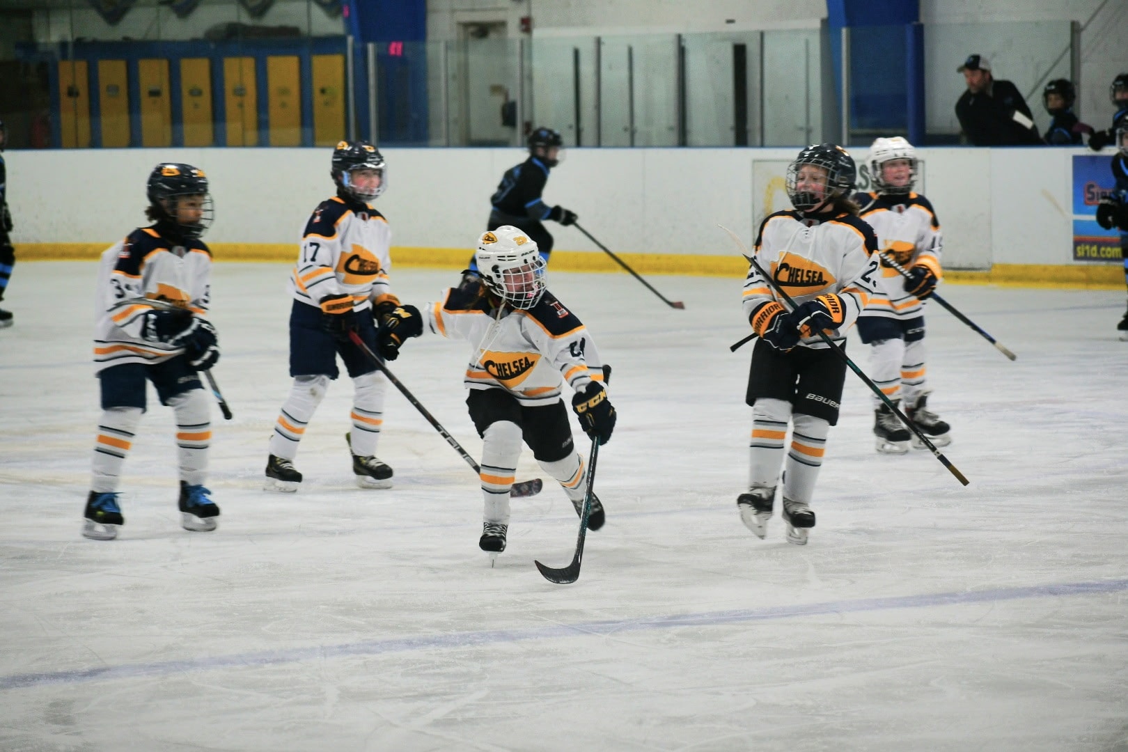 Youth hockey players in Chelsea uniforms skating during a game at a Chelsea, Michigan rink