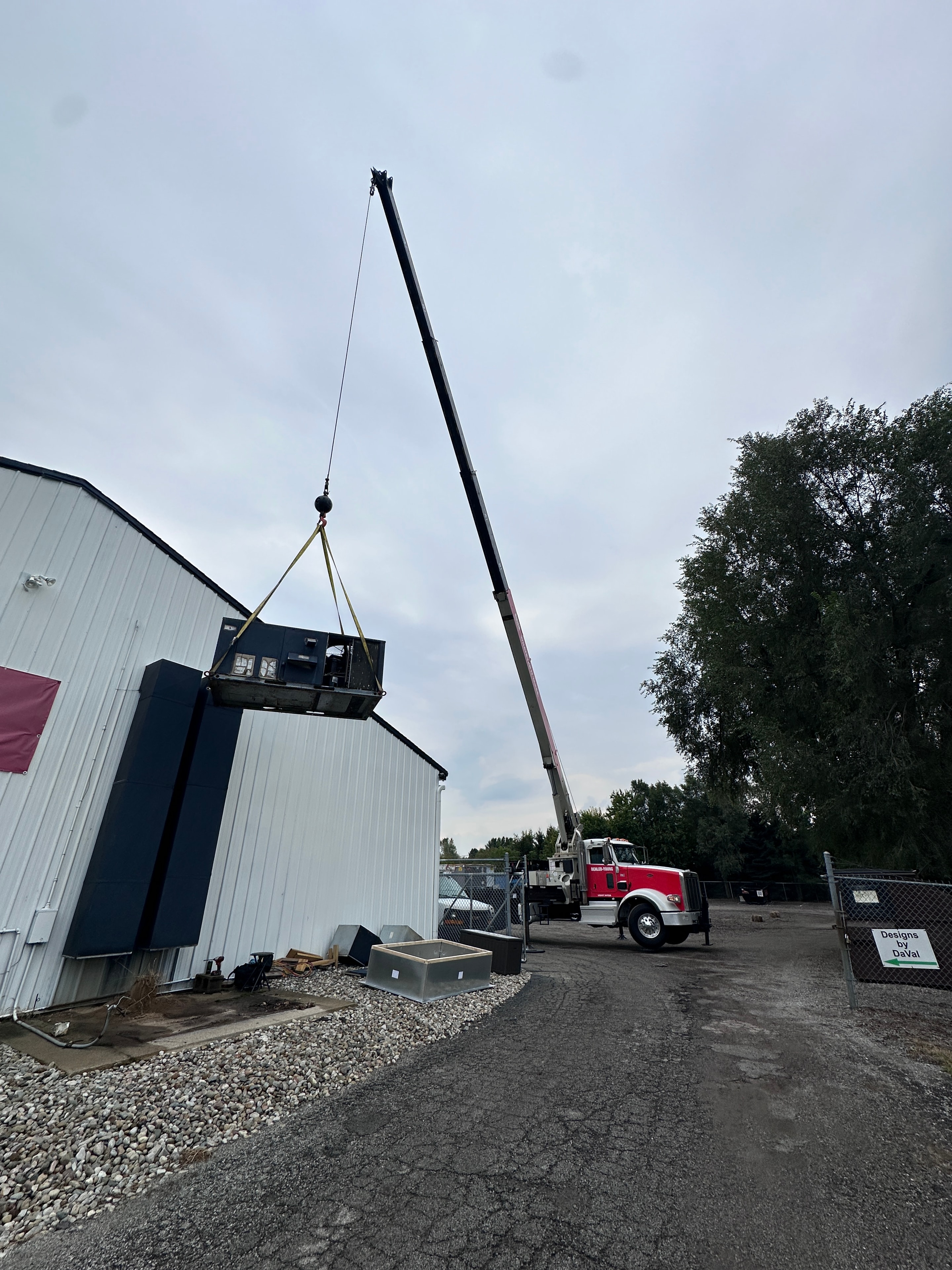 Crane lifting commercial HVAC rooftop unit into place during a commercial installation — HomeFlow Heating & Cooling, Southeast Michigan